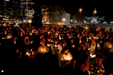 People Holding Candles at Memorial Vigil 